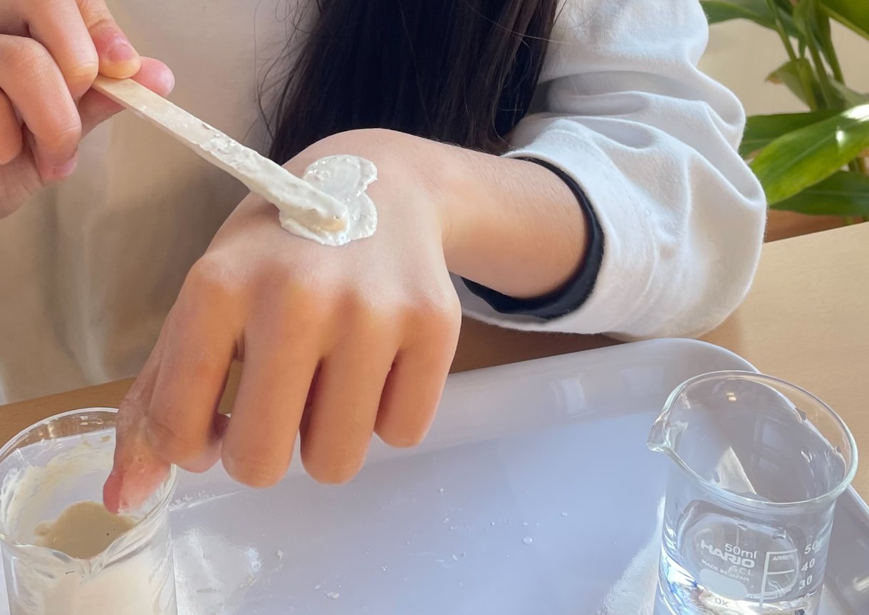 手の甲に植物クラフトを塗り、使用感を確かめる実習